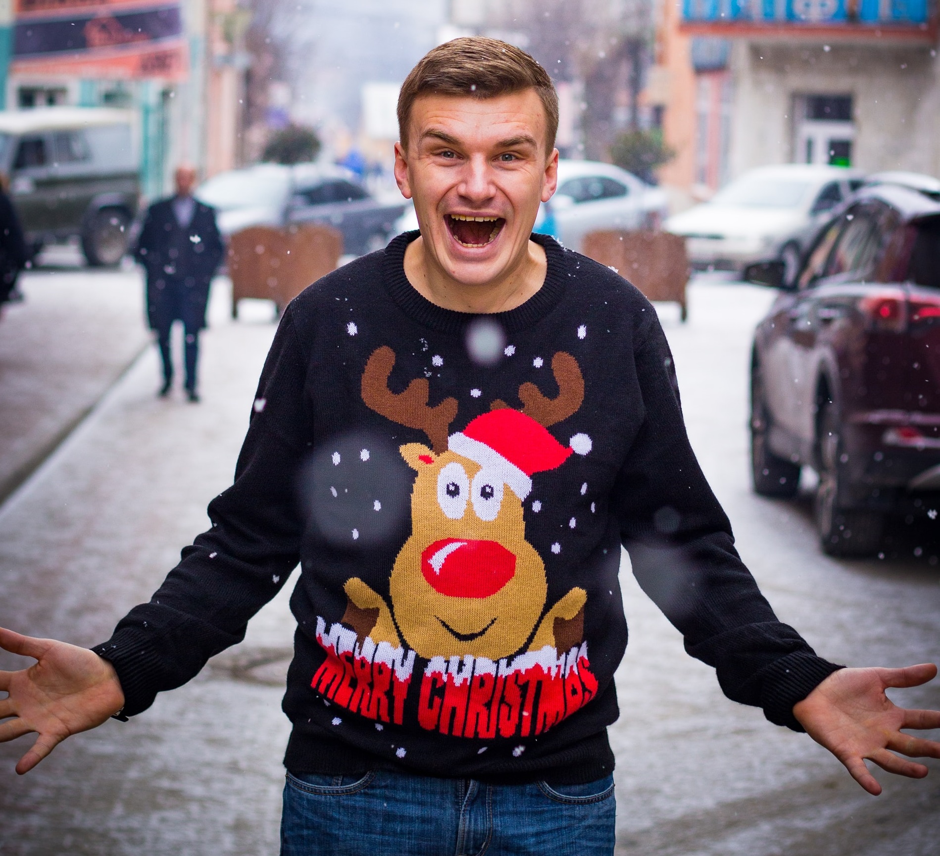 a man wearing an ugly holiday sweater with a reindeer on it