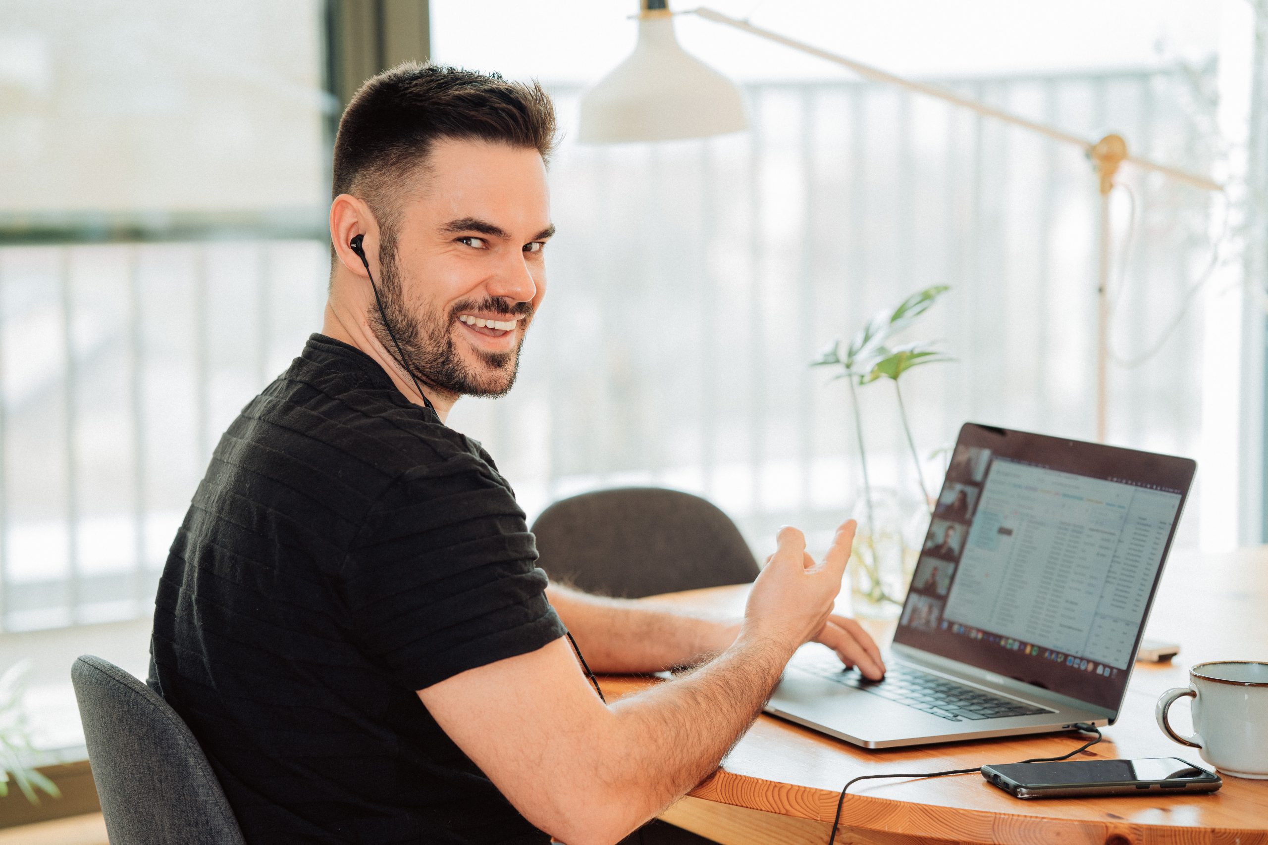 A man laughing while playing zoom games with his colleagues