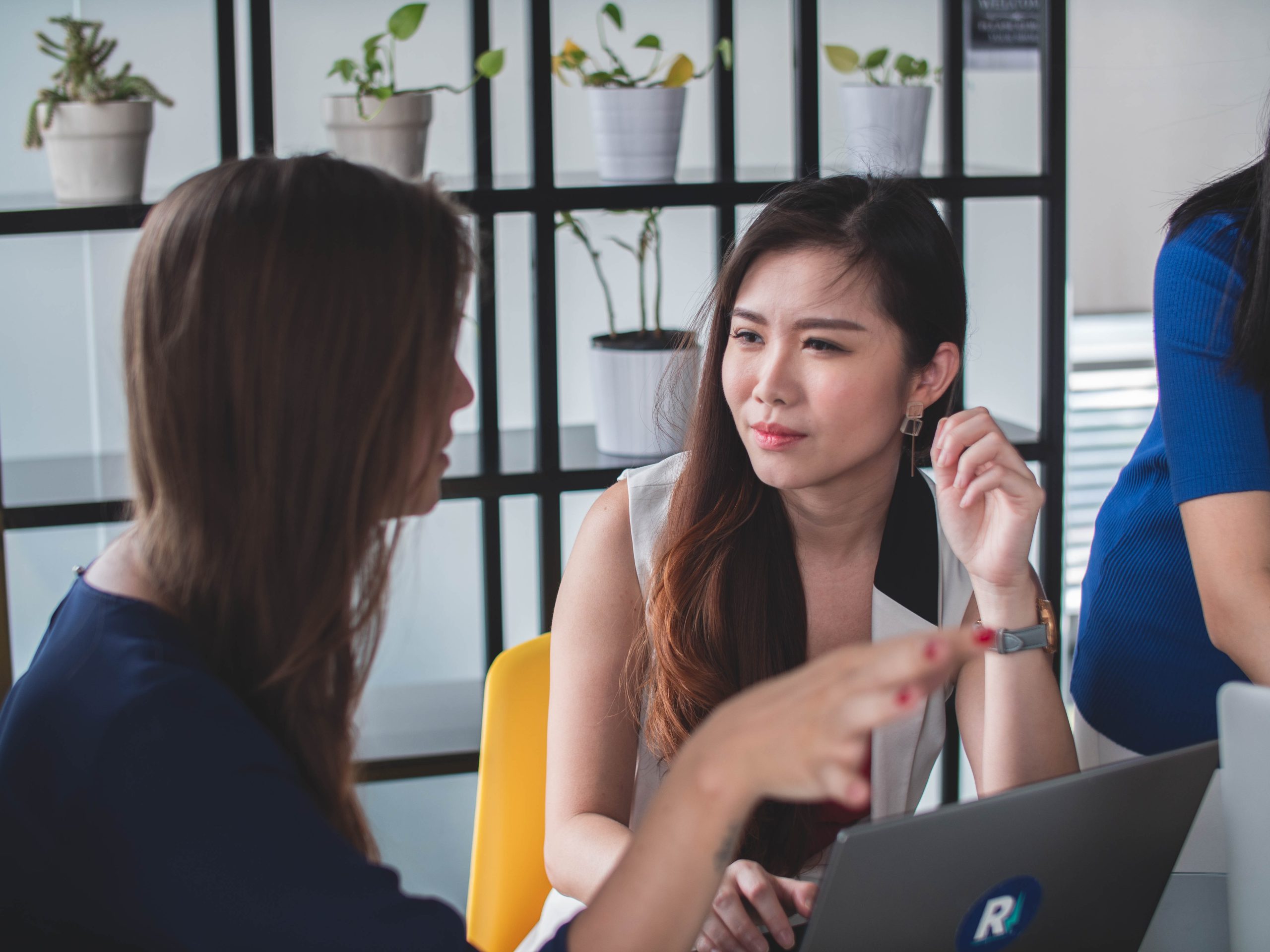 A project manager sitting with their team member listening intently and having a conversation in an office setting