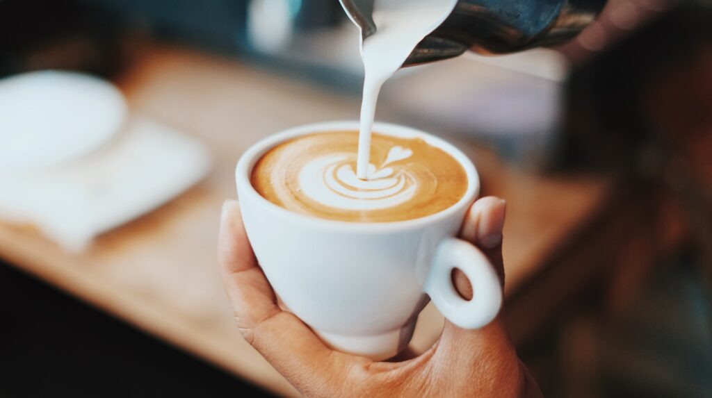 a barrista pouring a coffee for administrative professionals day