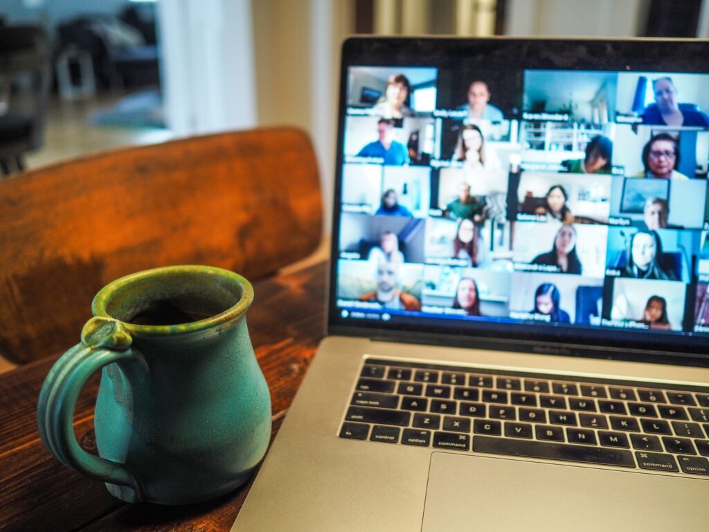 a group of colleagues participating in a virtual meeting to welcome their new remote colleague