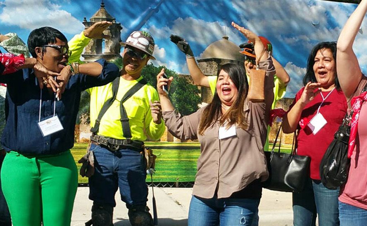 a group of colleagues taking part in a random acts of kindness team building activity for administrative professionals day