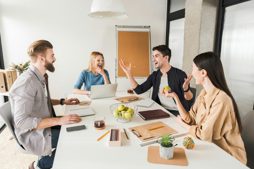 a team of colleagues doing icebreakers at the conference table as a fast team building activity before their meeting starts