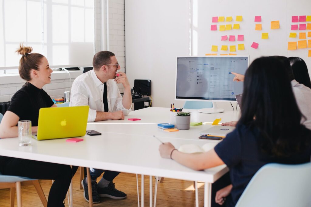 employees sitting in a meeeting looking at a screen together