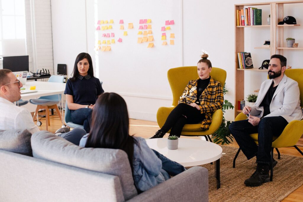 five employees sitting and having a productive meeting in their office space