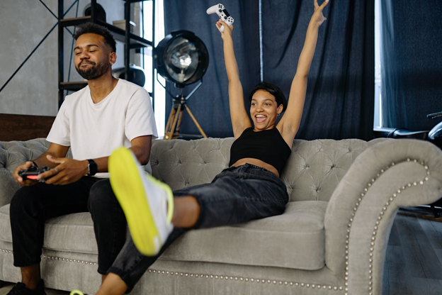 two employees playing a video game on the couch at their office