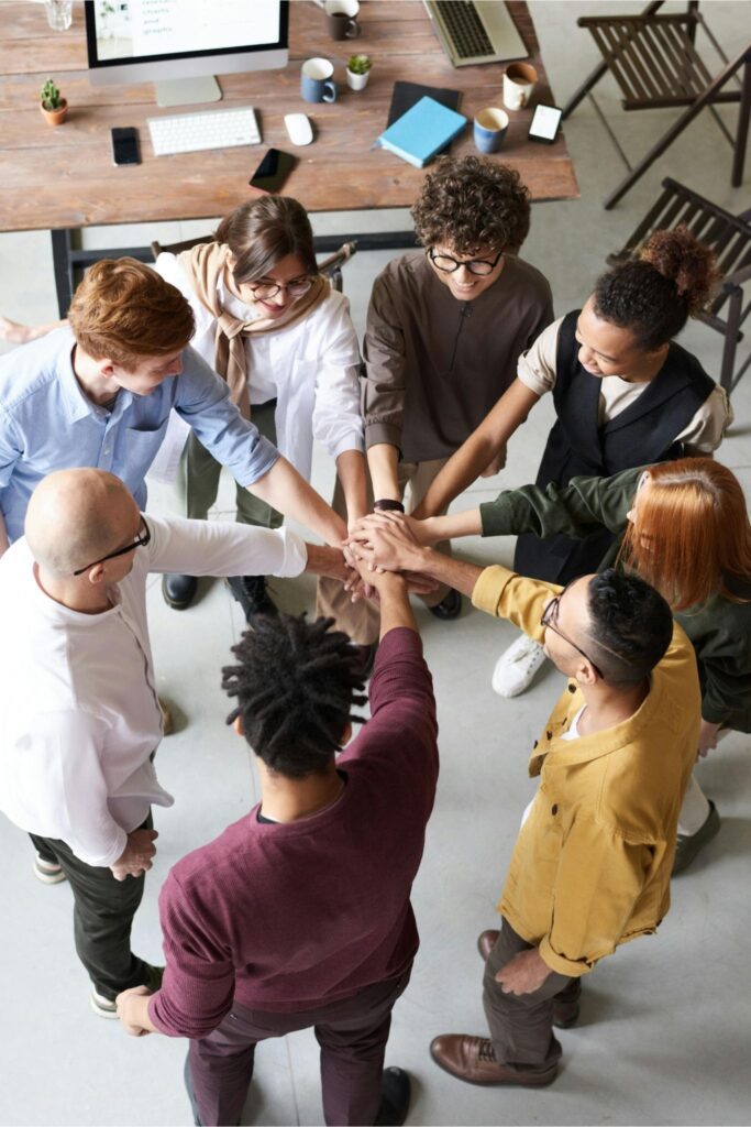 happy team stacking hands together in a team building session