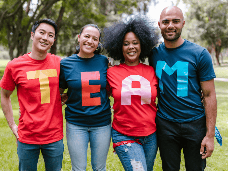 Happy coworkers wearing matching t-shirts at team building activity