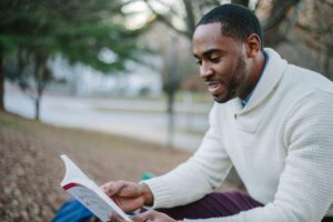 Man reading a self help book in a park