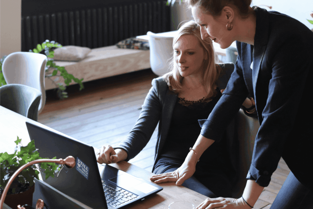 Employee and boss looking at a laptop and discussing a project
