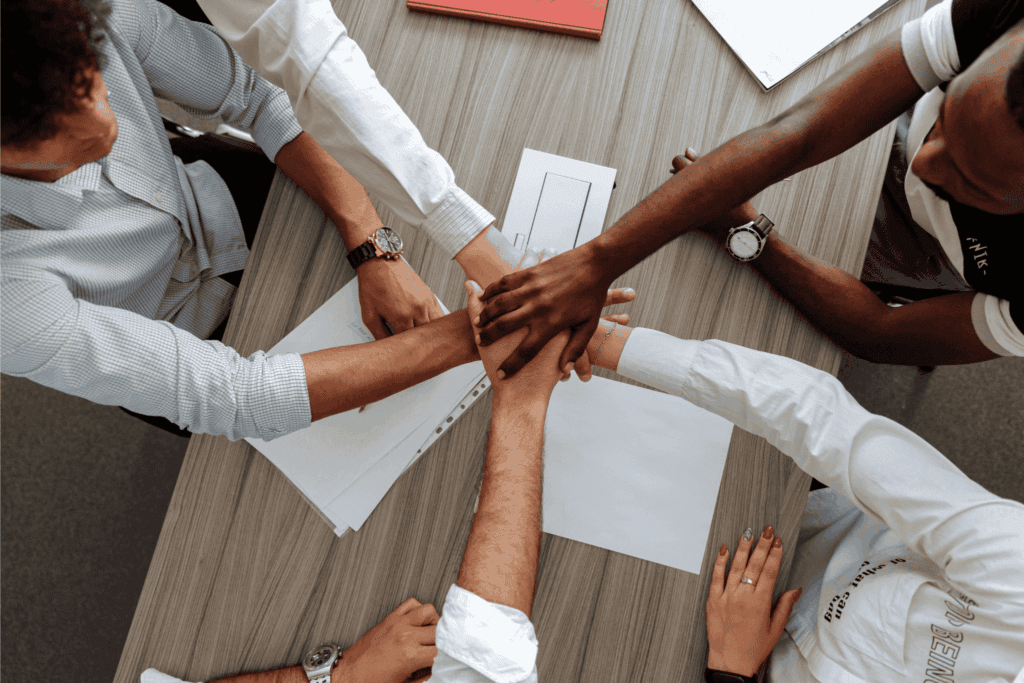 Coworkers piling hands during team building activity