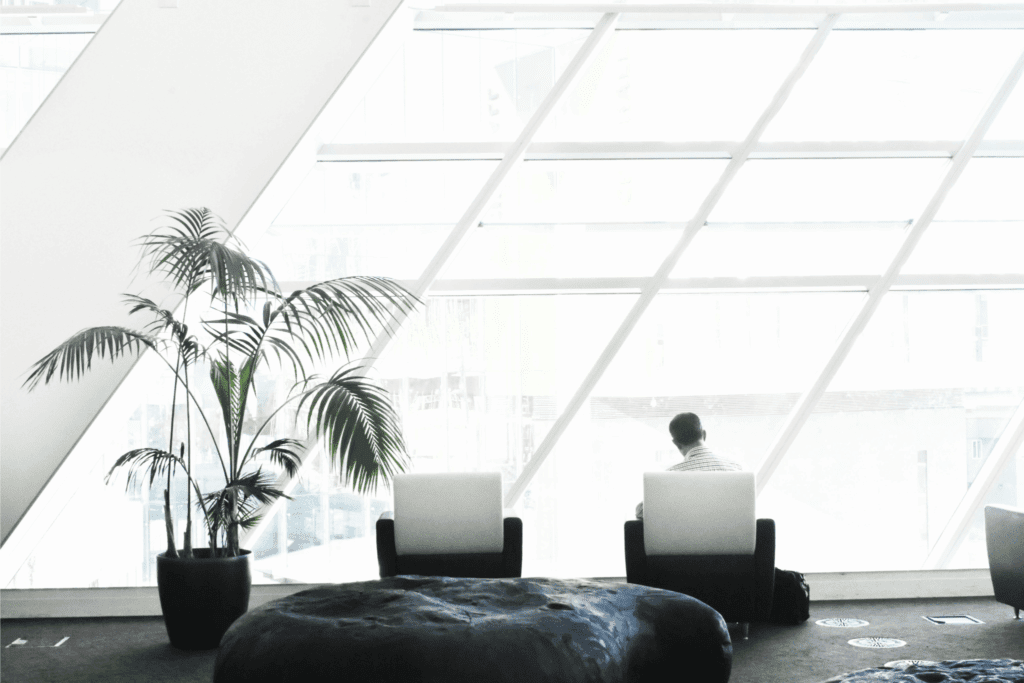 Man sitting in white, minimalistic office looking out the window