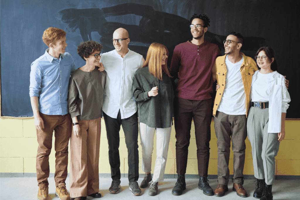 Bonded coworkers standing arm in arm and laughing