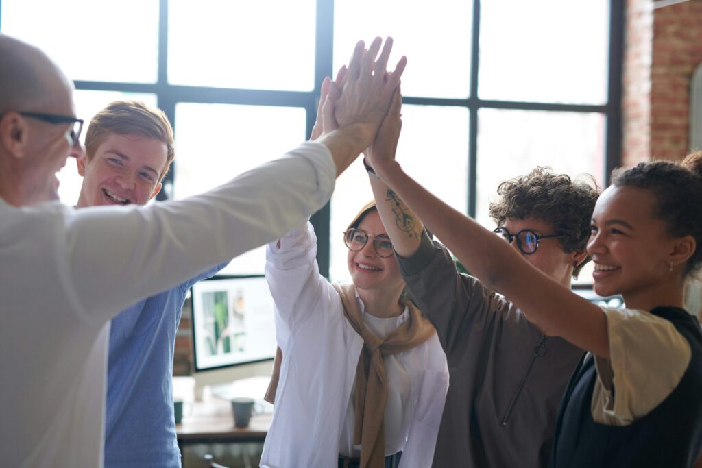 Bonded coworkers doing an enthusiastic group high five