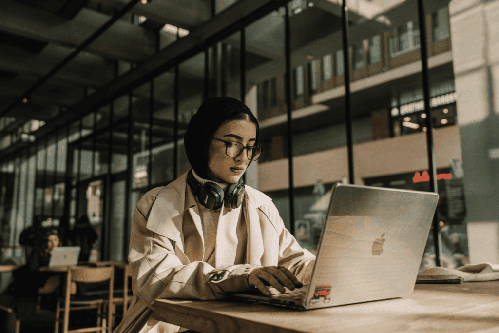 Focused woman working remotely on laptop in a modern café