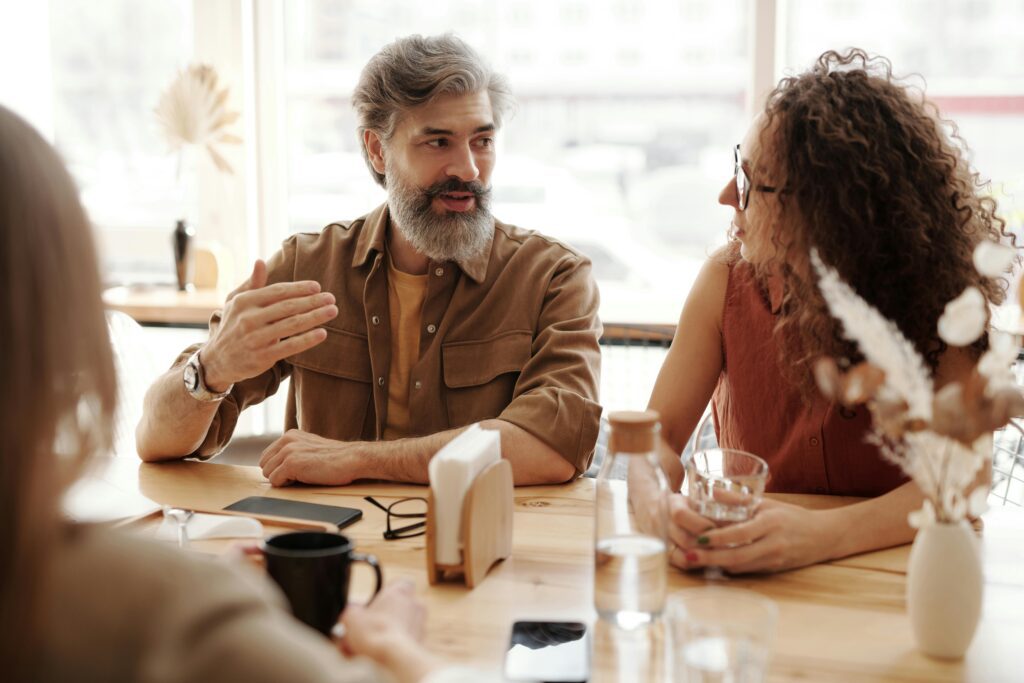 Professionals engaged in a relaxed business conversation over coffee