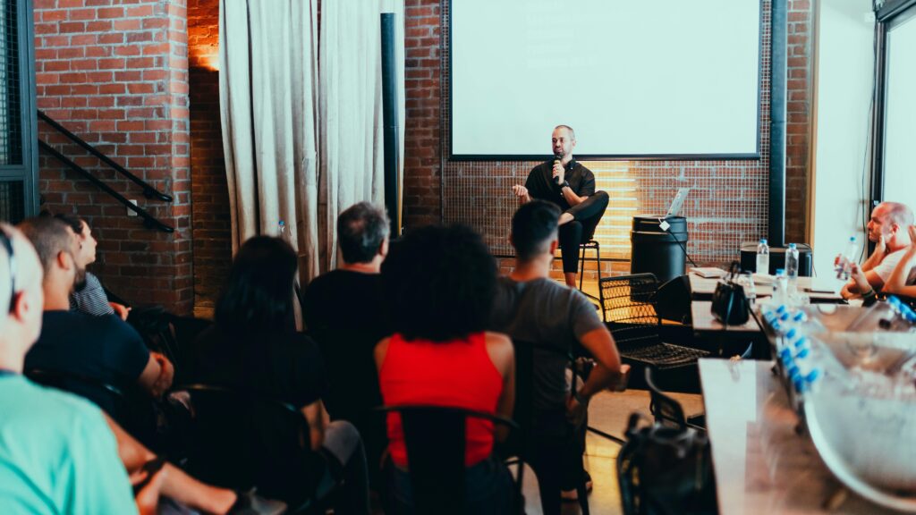 Speaker leads a business seminar in a modern coworking space, engaging attendees in professional development and networking