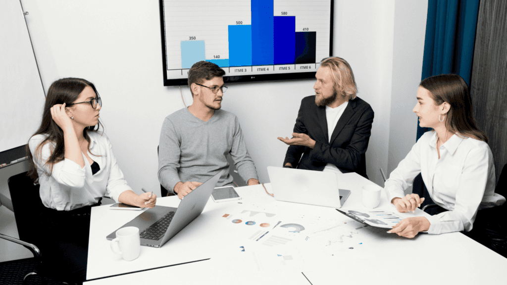 Data-driven team meeting in a modern office with professionals analyzing charts and business performance metrics