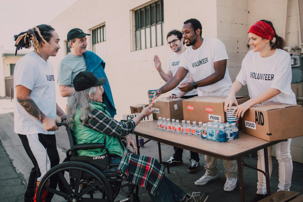 Volunteers distribute food and water to people in need at a community aid event