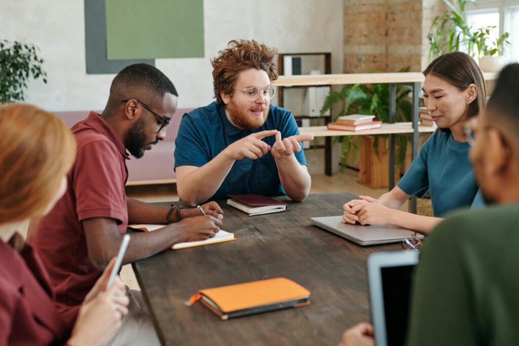 Coworkers engage in an animated discussion during a team meeting, collaborating and sharing ideas around a conference table