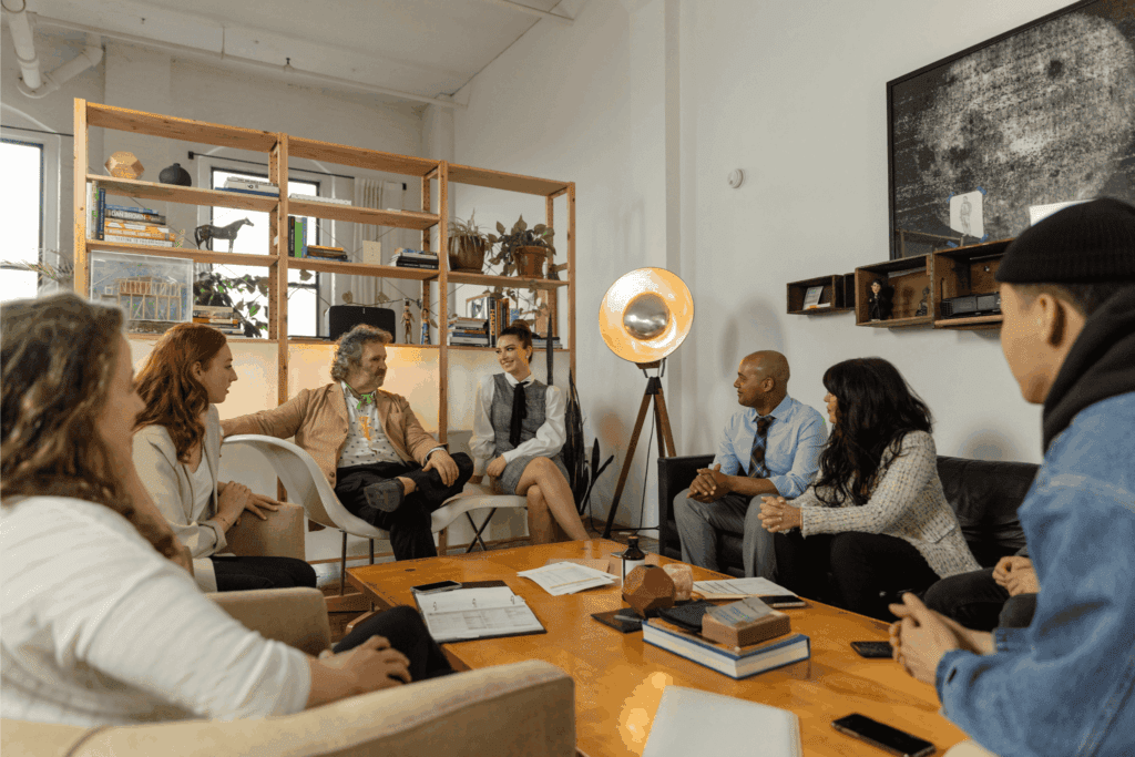 New employees participating in a relaxed onboarding session, engaging in team introductions and discussions in a modern, welcoming office space