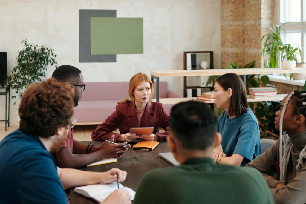 Team leader conducting an onboarding meeting with new employees, explaining company processes and goals in a collaborative workspace.
