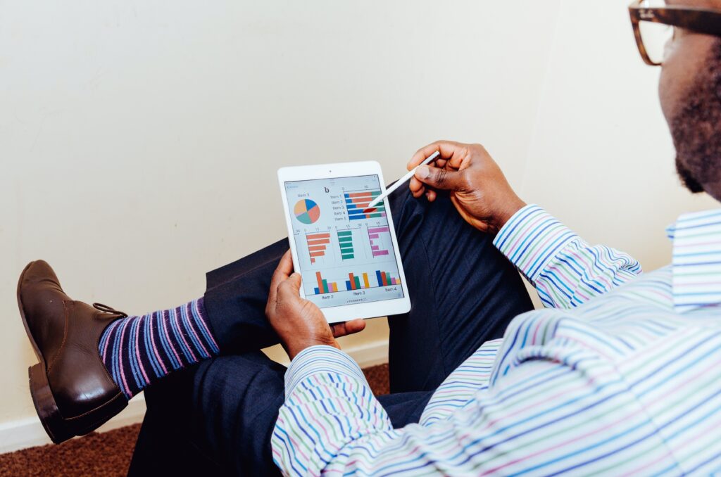 A project manager using an iPad to track the budget of their project using graphs and numbers 