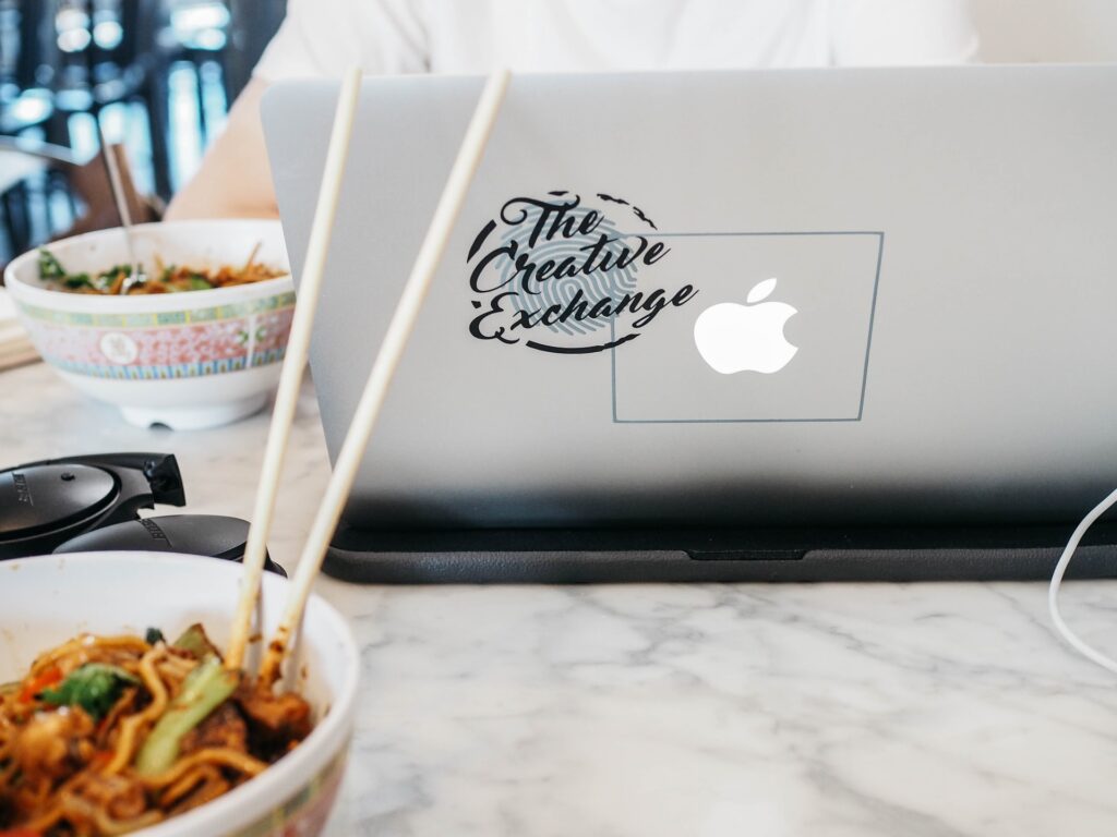 a table with a laptop and food at a lunch and learn 