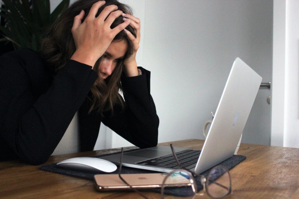 an employee at her computer feeling frustrated and experiencing work from home fatigue