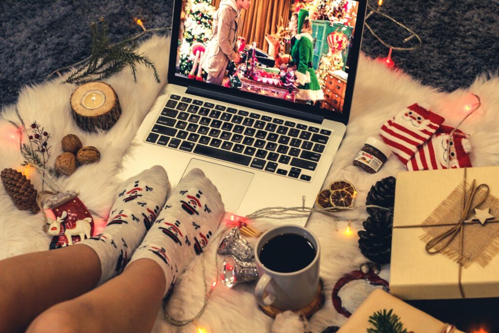 an employee watching a holiday movie on their laptop surrounded by decorations