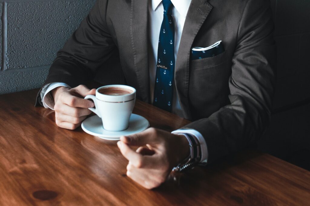a business leader drinking a cup of coffee in a nice suit