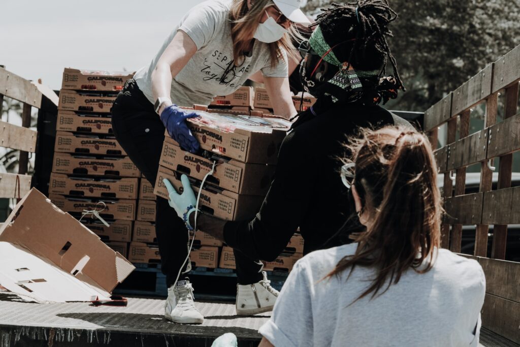 a work team volunteering and unloading food from a truck to donate