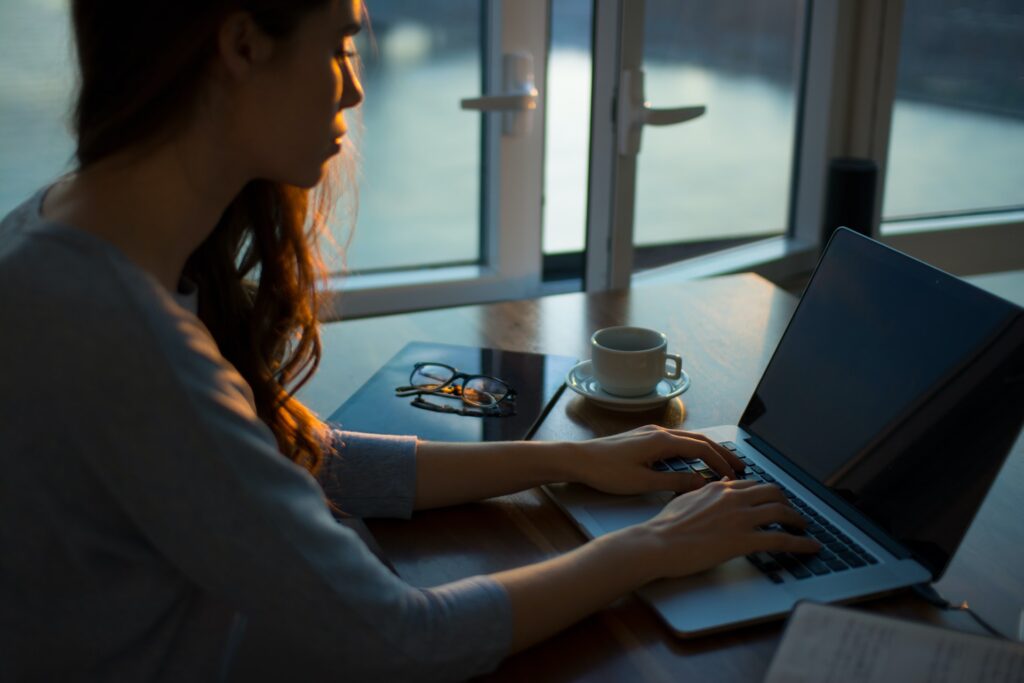 A woman working from home at her laptop by the window