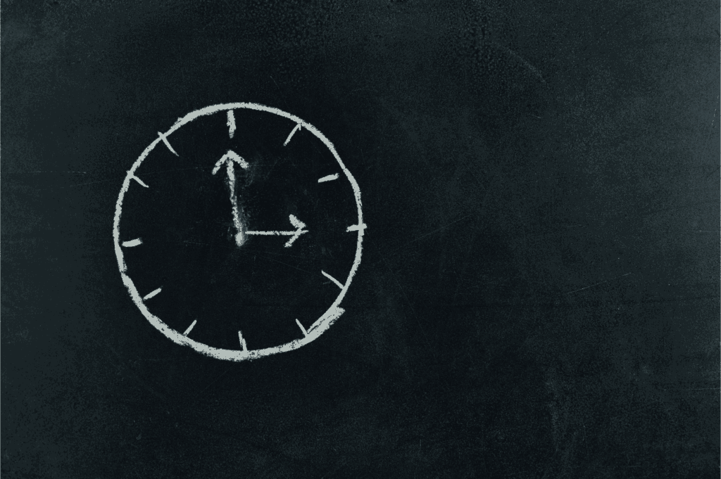 Chalk-drawn clock on a blackboard showing three o’clock – concept of time management and productivity.