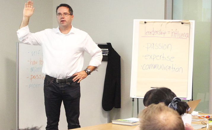 a facilitator leading a group of employees doing an emotional intelligence group skills training workshop