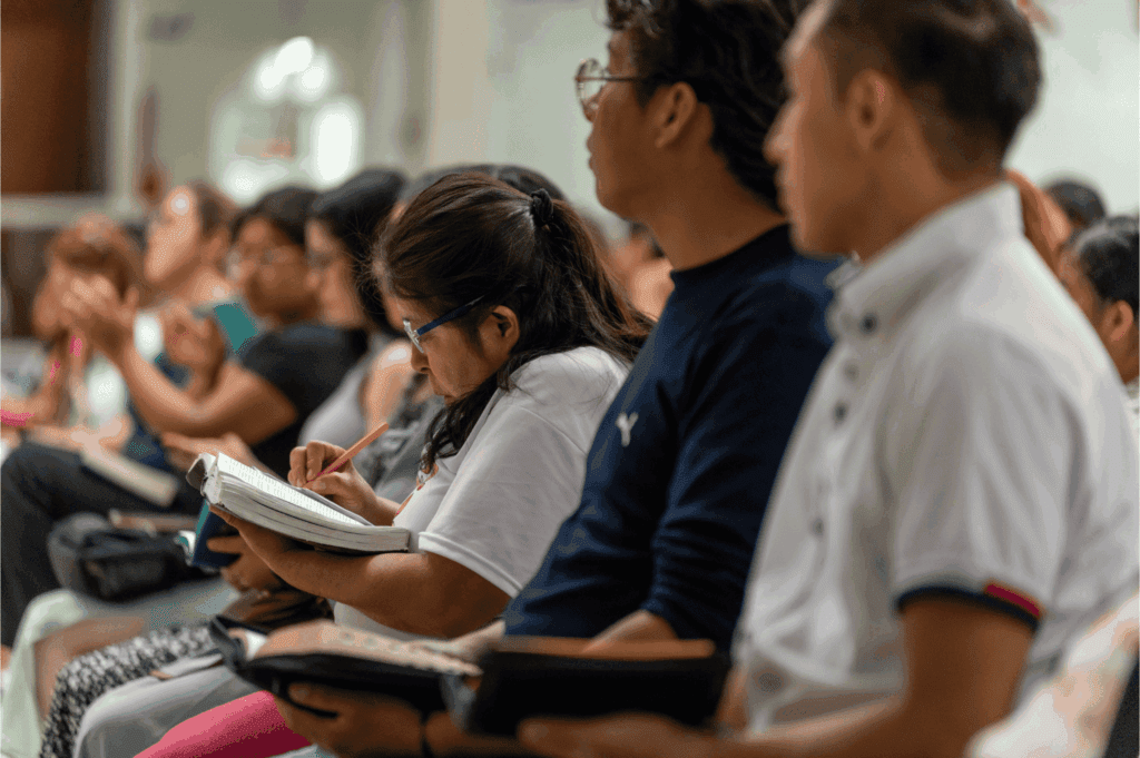 Students attentively listening and taking notes in a classroom setting – education, learning, and academic focus concept.