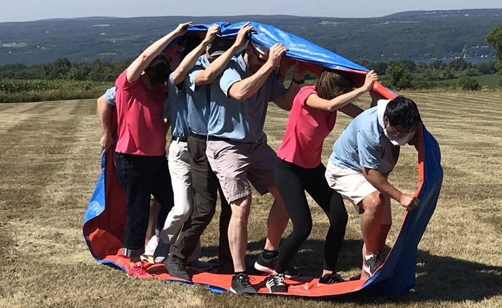 a group of colleagues doing a corporate castaways spring team building activity