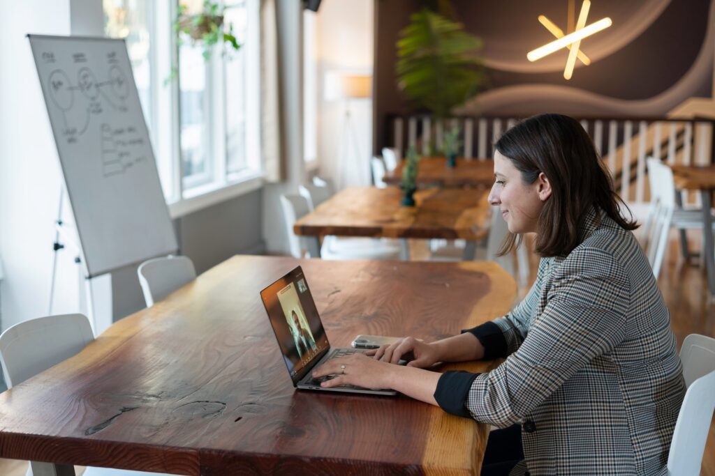 a woman at her desk taking part in an online office game with her remote colleagues