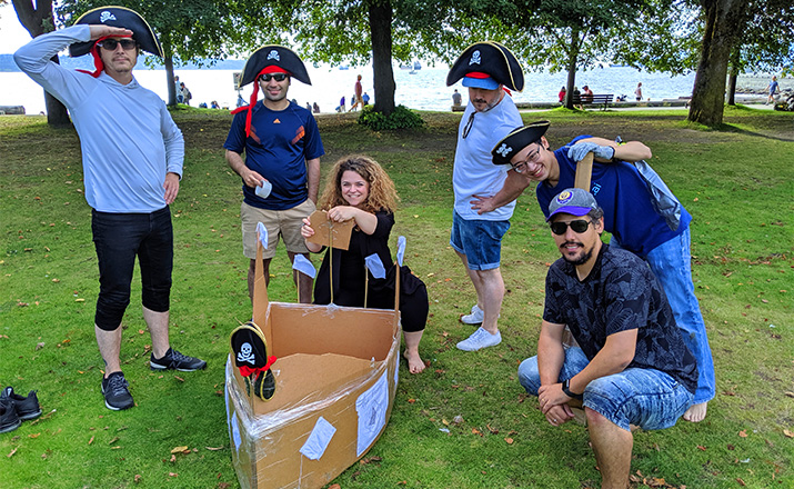 six colleagues doing a cardboard boat building challenge team building activity