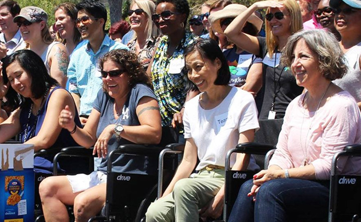 a group of colleagues taking part in a wheelchairs for charity outdoor team building activity