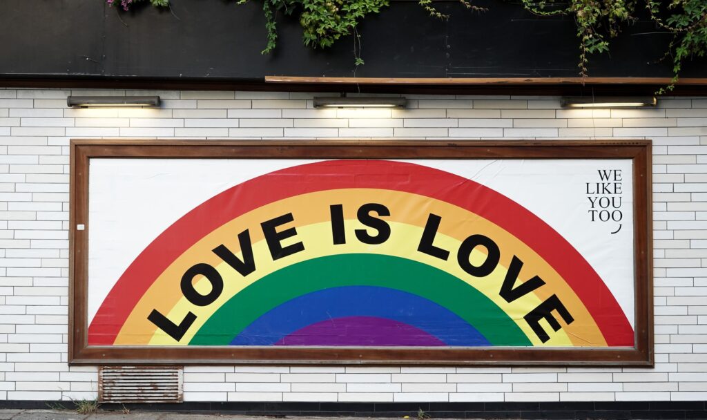 a mural on a wall featuring a rainbow and the words love is love for pride month