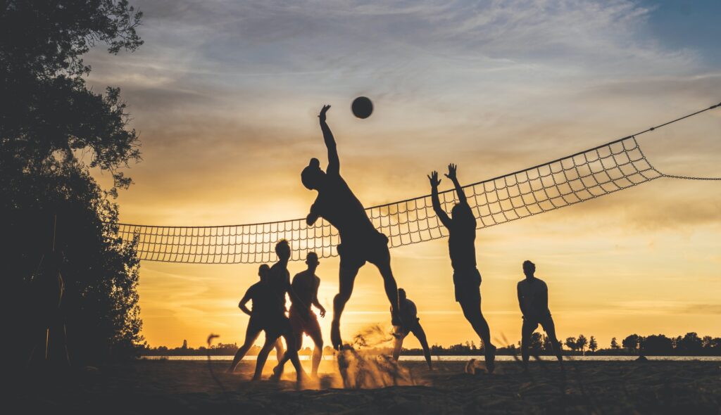 a team of colleagues playing beach volleyball on their company sports team