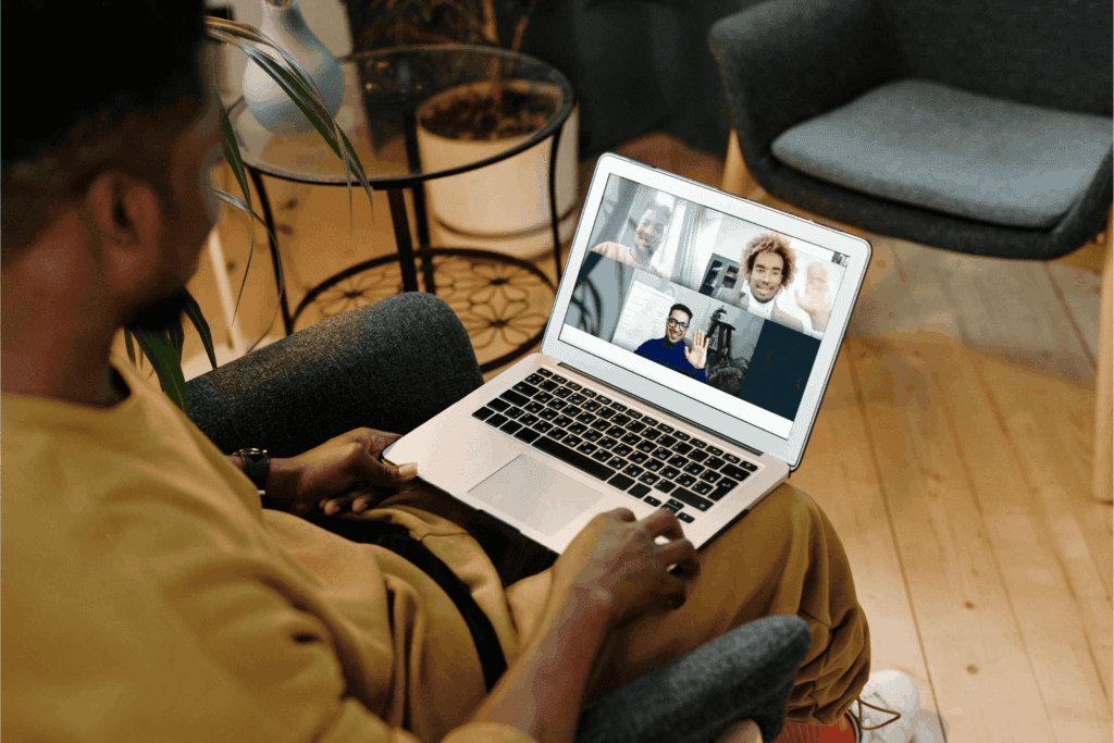 Man attending a virtual meeting on a laptop with multiple colleagues – remote work, online collaboration, and digital communication concept.