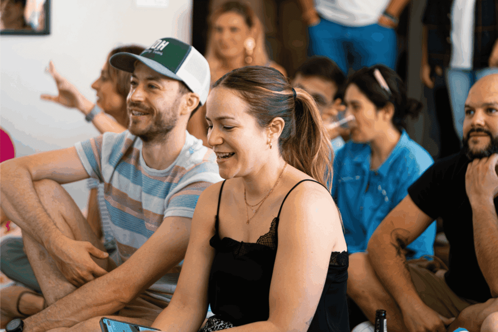 Team members sitting together and smiling during a casual gathering – teamwork, collaboration, and positive team building experience.

