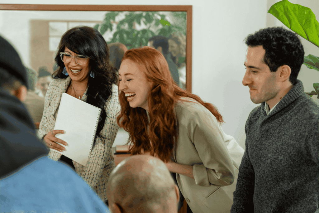 Coworkers enjoying a lighthearted moment during a meeting — teamwork and positive workplace culture concept.
