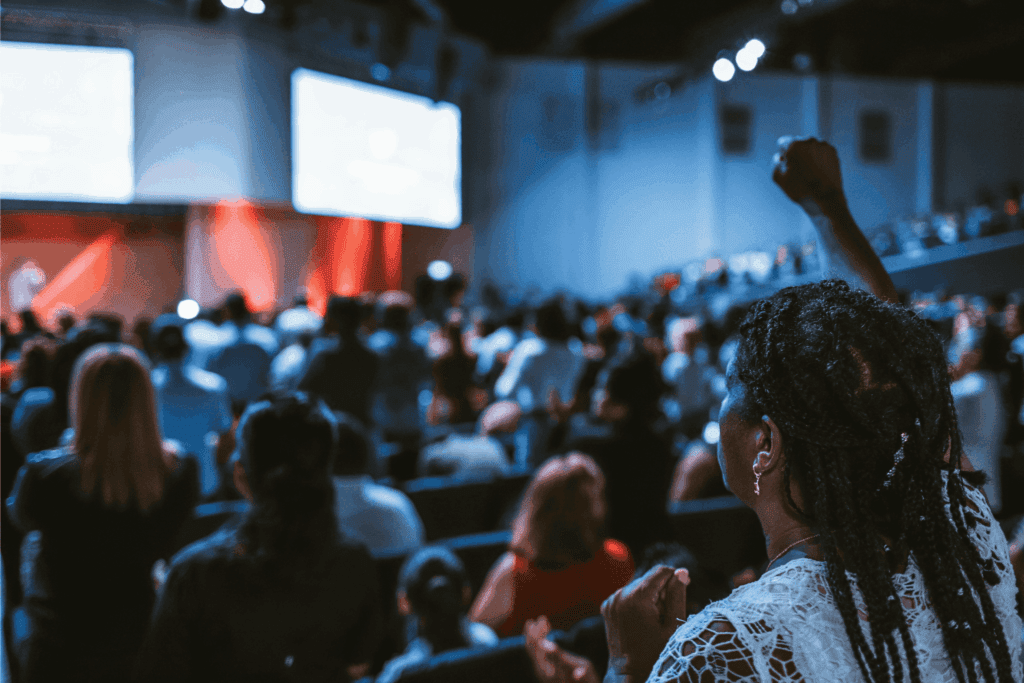 Employees unite in excitement and energy during a large team-building conference.