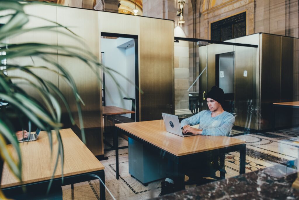 an employee at his desk on his laptop looking relaxed and focused in a beautiful workspace