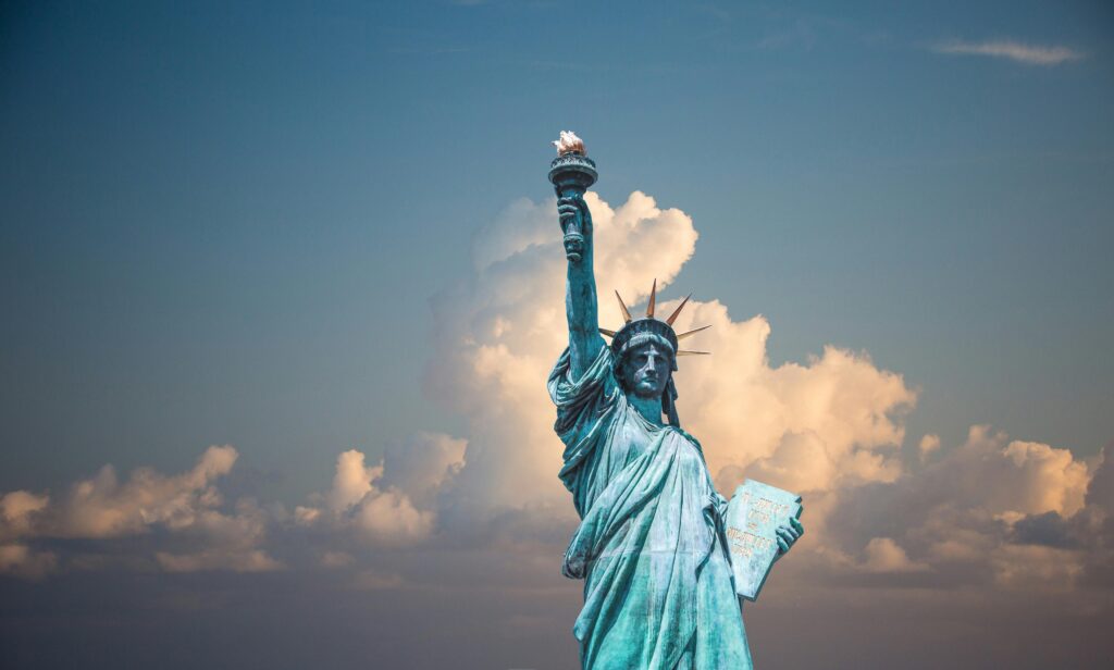 The Statue of Liberty stands tall against a backdrop of clouds, symbolizing freedom and American independence.