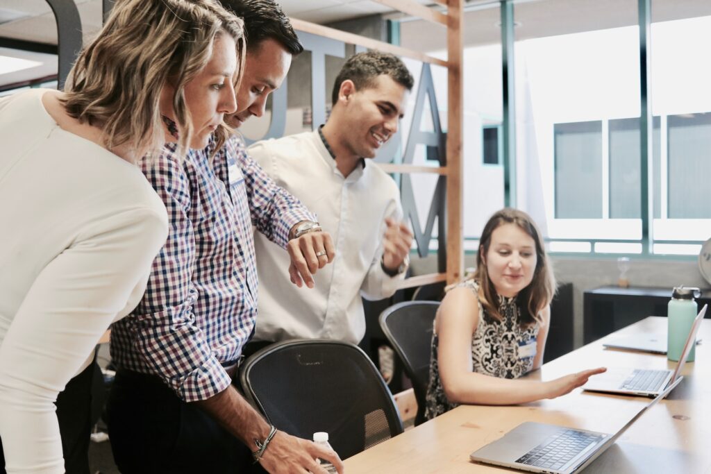 a group of happy employees collaborating at a desk