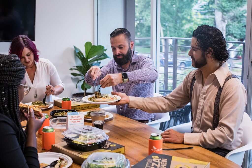 a small business team having lunch at a conference table for a lunch and learn